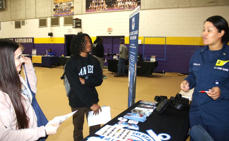 Karyss Butler (from left) and Christopher Hardman, two Columbia High seniors, get recruitment and career tips from Mary Sharpelletti, Chief Petty Officer with the USCG recruiting office in Jacksonville during the Columbia High School College and Career Fair on Thursday. (TONY BRITT/Lake City Reporter)