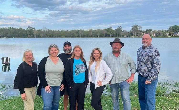 DeSoto Derby Canoe Race committee members Dana Solenski (from left), Brandy Meeks, Troy Markham, Lindsey Markham, Rosy Sparks, Chris Samson and Jerry Solenski, stand on the banks of Lake DeSoto. Elks Lodge #893 is hosting a canoe race this weekend on the lake as a fundraiser. (COURTESY)