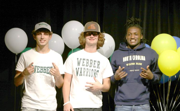 Fort White soccer players Gavin Heaton (left) and Connor Bass (right) signed their letters of intent with Webber International, while football player Maliki Clark (right) signed with North Carolina Wesleyan on Thursday. (MORGAN MCMULLEN/Lake City Reporter)