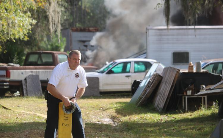 Lake City Assistant Fire Chief Dwight Boozer works with a hose at a fire. Boozer passed away Wednesday night after a battle with cancer. (FILE)