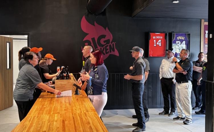 A line of first responders wait to order at Big Chicken during Tuesday’s sneak peek at the new Lake City restaurant. (JAMIE WACHTER/Lake City Reporter)