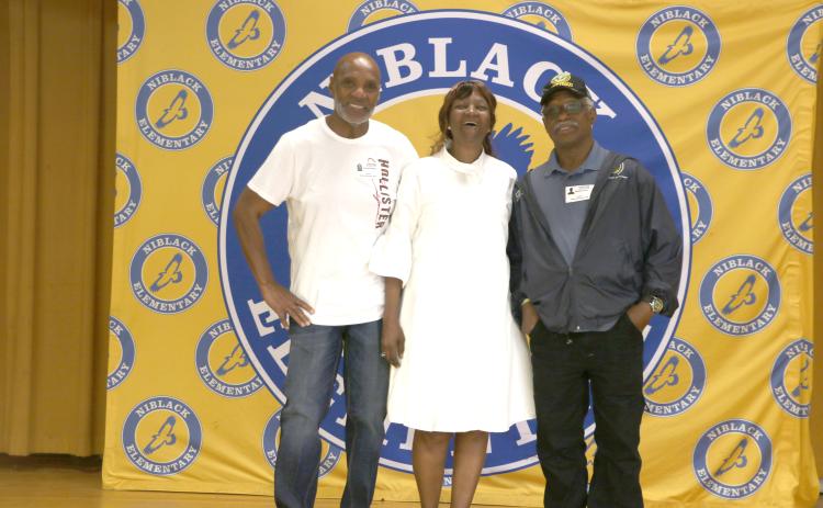 Niblack Elementary alumni Conrad Wallace (from left), Vallice Caldwell and Ronald Griffin gather on the stage in the Niblack cafeteria during Thursday’s tour. (MORGAN MCMULLEN/Lake City Reporter)