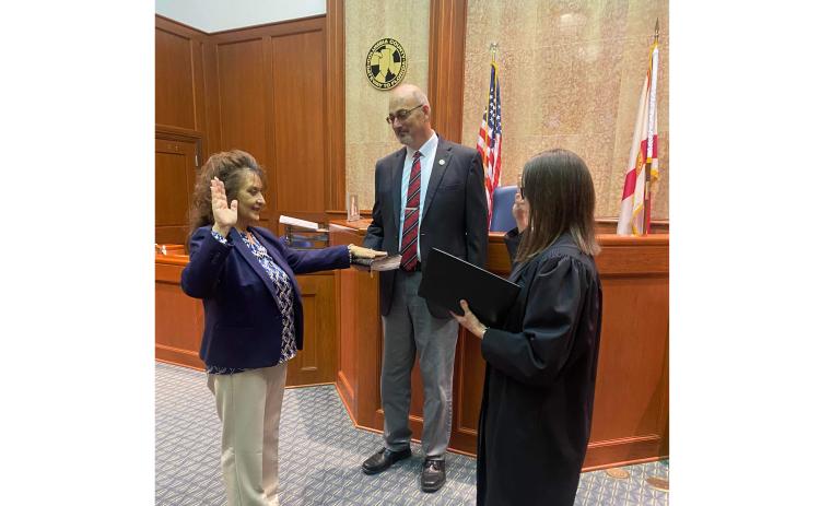 Tina Siefert (left) is sworn in as the Third Judicial Circuit’s new General Magistrate by Chief Judge Melissa Olin as Seifert’s fiancee John Blanchard holds the Bible during the private swearing-in ceremony Friday in the Columbia County Courthouse. (COURTESY)