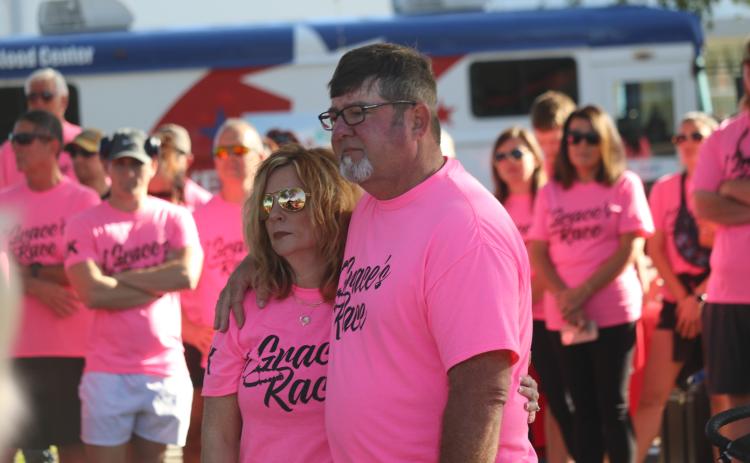 Grace Duncan’s parents, Burt and Cissy, listen during a prayer prior to the start of last year’s Grace’s Race 5K run/walk. The fourth annual event, which is held in Duncan’s memory, is set for Saturday. (FILE)