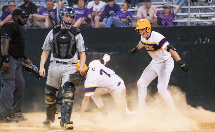 Columbia right fielder Max Schuler (right) celebrates as center fielder Bynton Edge (7) slides safely into home plate for an inside the park home run against Gainesville during Tuesday’s District 2-5A semifinal. (BRENT KUYKENDALL/Lake City Reporter)