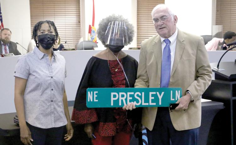 Lake City Mayor Stephen Witt holds up the NE Presley Lane sign next to Bernice Presley (middle) and Sharyn Presley (left) after the Lake City Council agreed to rename NE Railroad Street in honor of the Presley family. (MORGAN MCMULLEN/Lake City Reporter)