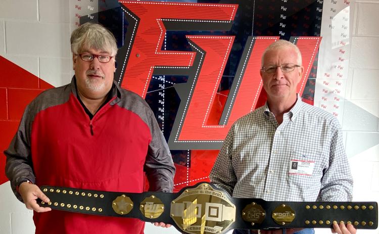 Fort White High School Principal Keith Couey (left) displays the championship belt alongside FDOT District Two Secretary Greg Evans. Fort White students increased their seatbelt wearing by 25% during the course of the competition. (COURTESY)