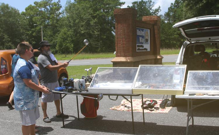 Some shoppers check out golf clubs at a previous United Way of Suwannee Valley community yard sale. (FILE)