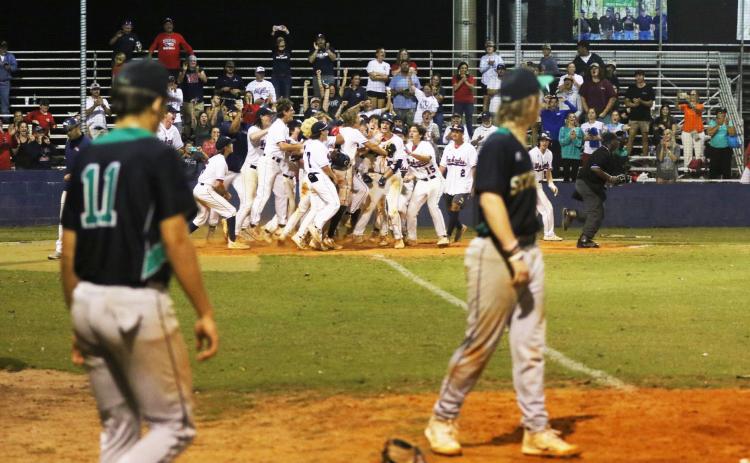 Suwannee’s Logan Brooks and Grayson Greene look on at Wakulla’s celebration at home plate following Hayden Klees’s walk-off home run in the Region 1-4A quarterfinals on Wednesday. (MORGAN MCMULLEN/Lake City Reporter)