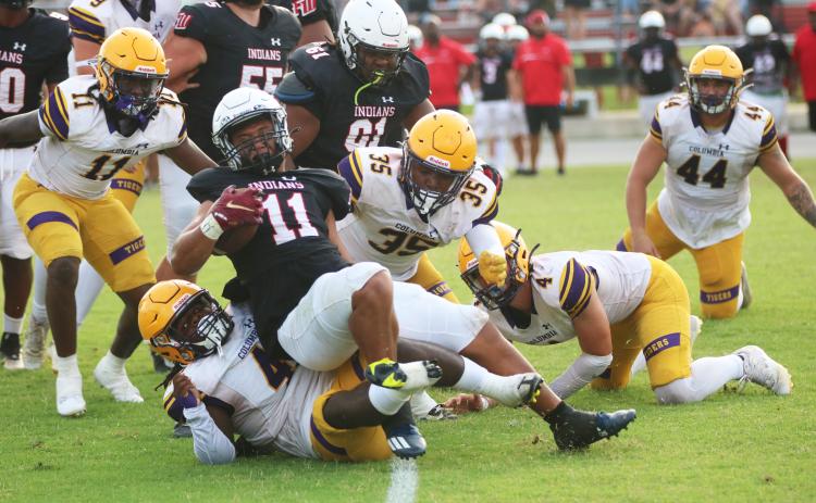 Fort White running back Lecosta Byrd is tackled by Columbia defensive lineman Terry Henry during Friday’s spring game. (JORDAN KROEGER/Lake City Reporter)
