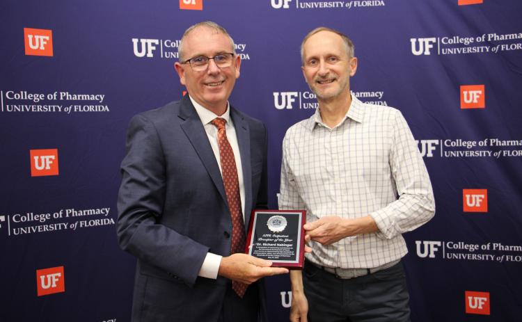 Dr. Richard Nabinger, pharmacist at the Baya West Pharmacy, receives the Advanced Pharmacy Practice Experience Outpatient Preceptor of the Year award from Peter Swaan, dean of the University of Florida College of Pharmacy, at the college’s graduate awards celebration Friday. (COURTESY UF COLLEGE OF PHARMACY)