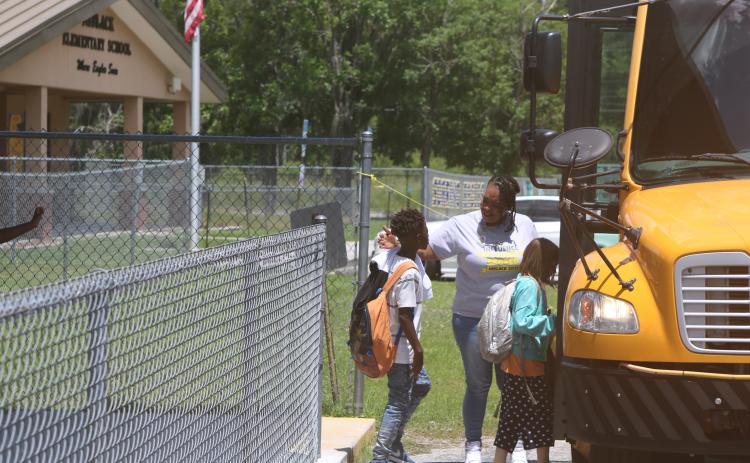 Makeba Murphy, Niblack Elementary School principal, hugs students on the final day of school before they board their buses. The Niblack school building is scheduled to be demolished in a few weeks and a new school building erected on the site. (TONY BRITT/Lake City Reporter)
