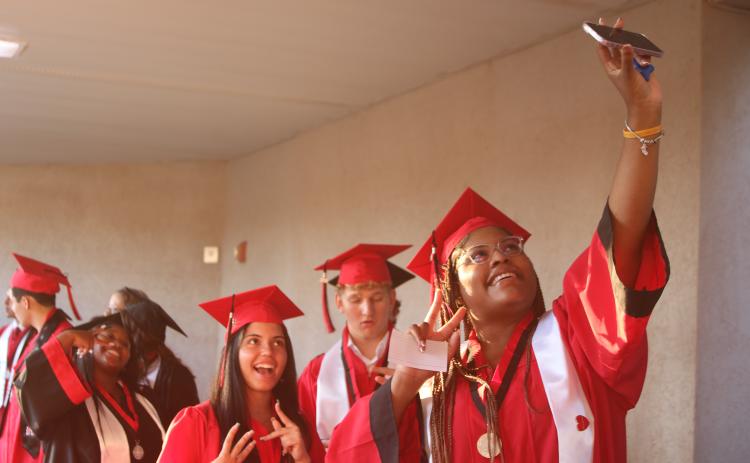 Keyonis Alexander takes a selfie with her classmates as Fort White High School graduation candidates head to the stadium for the school’s commencement exercise on Friday night. (TONY BRITT/Lake City Reporter)
