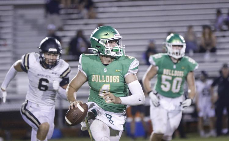 Suwannee quarterback Thomas Sikes looks for a receiver as he rolls out against Buchholz during Thursday's spring jamboree at Langford Stadium. (JAMIE WACHTER/Lake City Reporter)