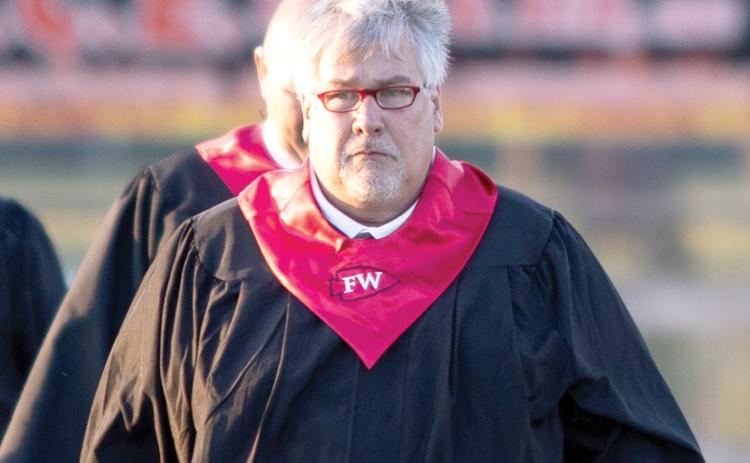 Fort White High Principal Keith Couey walks on to the Arrowhead Stadium field last month for graduation. Couey is being moved to the district office as he prepares to be the district superintendent. (RAY CARPENTER/Special to the Reporter)