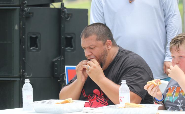 Steven Flores takes part in the hot dog eating contest during the Rotary Club of Lake City’s Independence Day celebration last year at Wilson Park. The hot dog eating contest will be back as part of this year’s event. (FILE)
