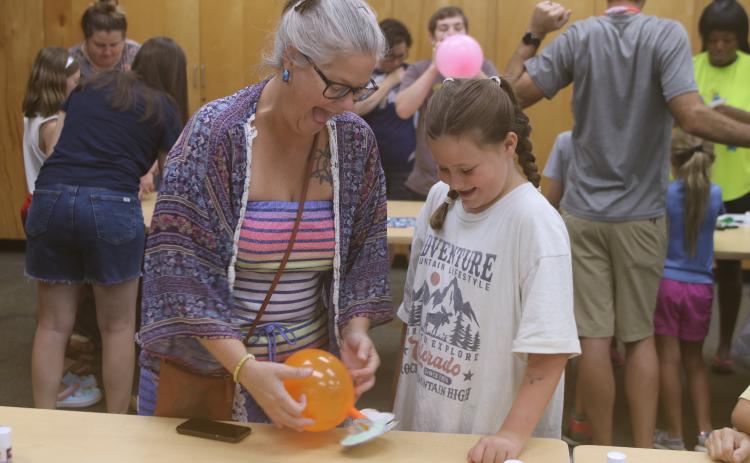 Laura Hicks (from left) and her daughter, Ava Wilson, enjoy testing out their hovercraft experiment at the Columbia County Public Library’s STEAM lab Friday. (TONY BRITT/Lake City Reporter)