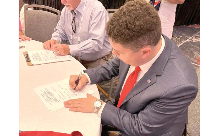 Hunter Peeler, the Columbia County Republican Party chairman, signs paperwork Monday at the Republican National Convention to nominate Donald Trump as the Republican presidential candidate. (COURTESY)