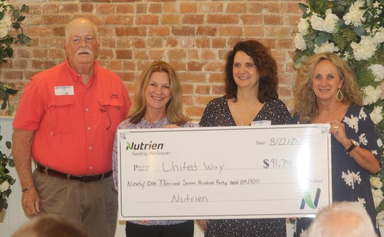 Don Fenneman (from left), stands with Jennifer Anchors, Bebe Willis and Pam Hyde as he presents a  check for $91,740 to the United Way of Suwannee Valley during the agency’s breakfast meeting on Thursday. (TONY BRITT/Lake City Reporter)