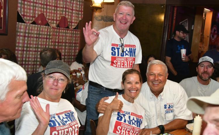 Suwannee County Sheriff Sam St. John (right) was all smiles Tuesday night after defeating challenger Jason Rountree in the primary election for sheriff. St. John was accompanied by Chief Deputy Buddy Williams and his wife, Tori St. John. (ROB WOLFE/Lake City Reporter)