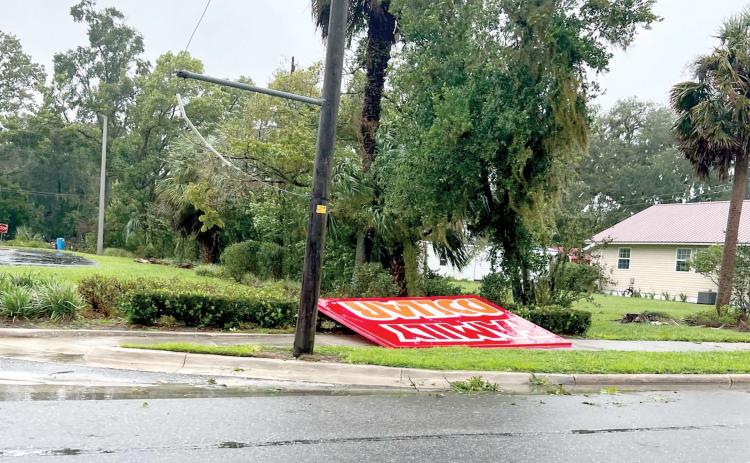 A Family Dollar sign was blown down onto the sidewalk along U.S. Highway 27 in Mayo during Hurricane Debby on Monday. (COURTESY)