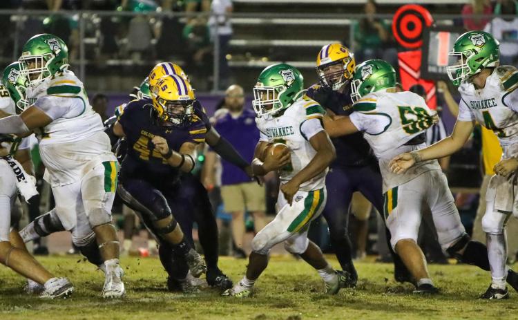 Suwannee running back Lou Jack Smith looks for running room as Columbia defensive lineman Caden Bolstein rushes in for a tackle last Friday. (BRENT KUYKENDALL/Lake City Reporter)