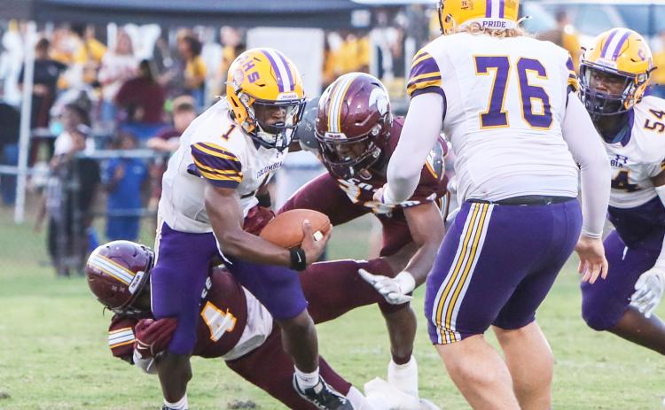 Columbia quarterback Zamarion Jones is bottled up by a pair of Coffee defenders on Friday night. (BRENT KUYKENDALL/Lake City Reporter)