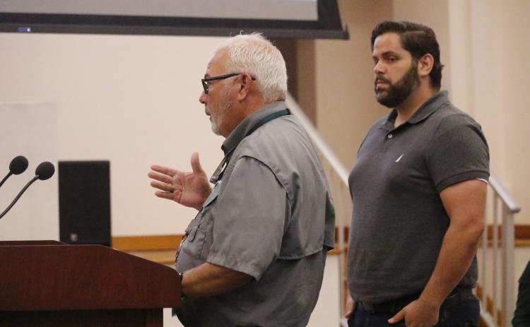 Columbia County Code Enforcement Officer Winston Warner talks to the County Commission about issues with complaints in the Town of Fort White on Thursday while Alexander Veiga, co-owner of The Collective: Food Yard and Garden, looks on. The commission voted to terminate its agreement to handle code enforcement for the town. (JAMIE WACHTER/Lake City Reporter)