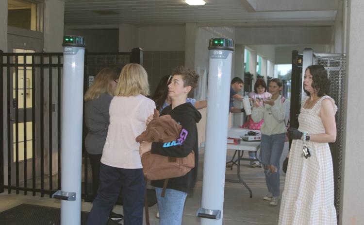 A Fort White student anxiously looks at the detection lights on one of the school’s new metal detectors while passing through. Fort White High added four metal detectors Monday morning to increase school security after threats last week. (TONY BRITT/Lake City Reporter)