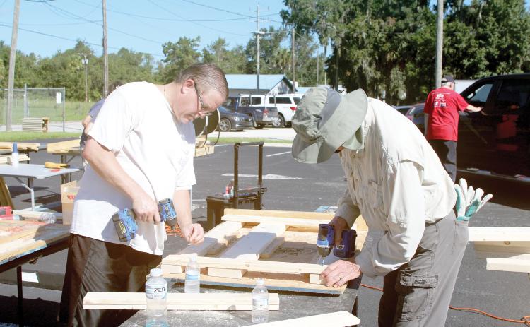 Chris Costello (from left) and Steve Stafford work on making a headboard during the Sleep in Heavenly Peace Bunks Across America event Saturday at the Christian Service Center. Volunteers planned to make 20 beds during the event. (TONY BRITT/Lake City Reporter)