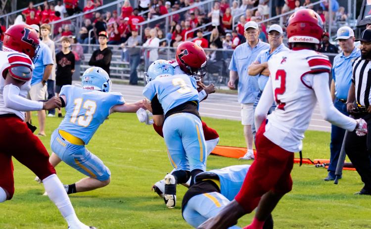 Lafayette quarterback Tywan Williamson is hit hard by Chiefland safety Jolan Doty on Friday. (JACK HOWDSHELL/Lake City Reporter)