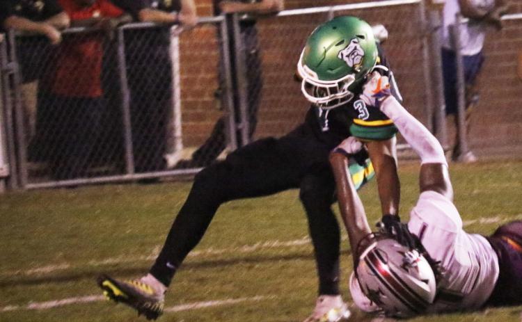 Suwannee running back Lou Jack Smith is tackled for a loss by Madison County’s Kemari Scurry on Friday. (JAMIE WACHTER/Lake City Reporter)