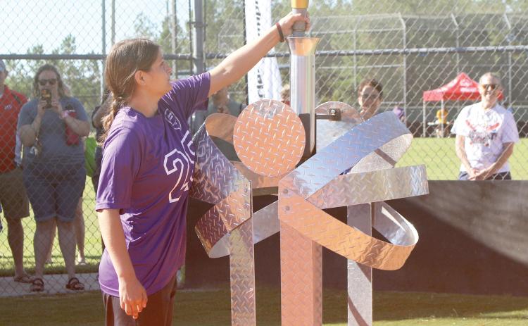 Columbia County athlete Rachel Saye places the torch into a stand during the opening ceremonies Saturday at the Southside Sports Complex. (TONY BRITT/Lake City Reporter)