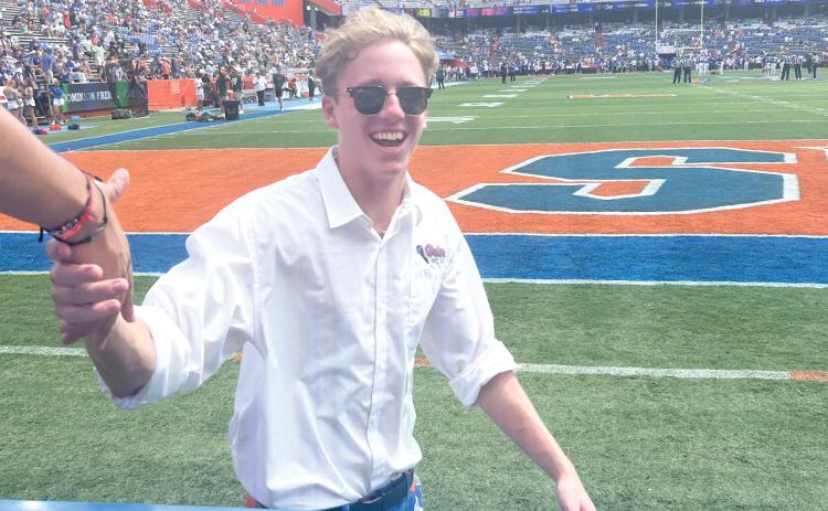 Florida Mic Man Drew Hingson, 19, of Lake City, greets Gator fans in the student section at The Swamp on Saturday. Hingson, was selected for the Mic Man job 10 days before the home opener and joined the Florida Cheer Squad after an open tryout on campus. He is a sophomore at UF. (COURTESY)
