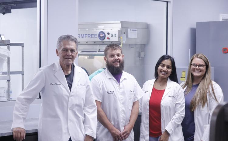 Baya Pharmacy East has added a sterile compounding lab in which it will start producing its own weight-loss drugs for customers. Pictured in front of one of the sterile machines in one of the sterile rooms at the pharmacy are Baya Pharmacy owner Carl Allison (from left), pharmacist AJ Ward, Director of Clinical Sciences Shivani Mehta and pharmacist Danae Ray. Mehta and Ward are certified to operate the sterile compounding lab and hazardous compounding lab. (JAMIE WACHTER/Lake City Reporter)