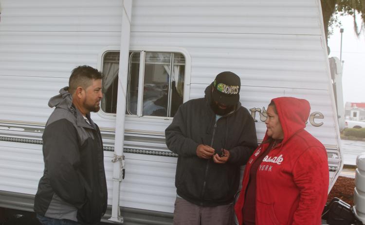Amanda Ramirez (right) and her family members hold a conversation while their camper is parked in the Walmart parking lot. Ramirez and family evacuated from Manatee County a few days ago to avoid Hurricane Milton. (TONY BRITT/Lake City Reporter)