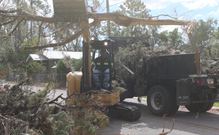 A Lake City Public Works employee helps clear debris from the roadside left in the wake of Hurricane Helene. Lake City Executive Director of Utilities Steve Brown, who also oversees public works, said additional crews have been brought in to help with the effort. (TONY BRITT/Lake City Reporter)