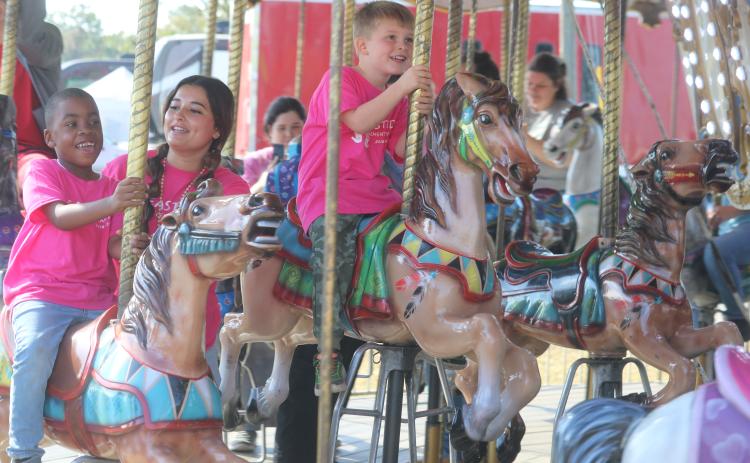 De’Mari Jackson (from left), Mya Villar and Parker Spin, are all smiles while riding the carousel Tuesday morning at the Florida Gateway Fair. (TONY BRITT/Lake City Reporter)