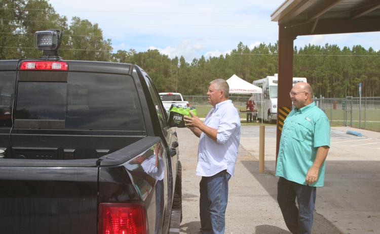 State Rep. Chuck Brannan (left) and Columbia County Commissioner Rocky Ford help pass out drinks and food to people mpacted by Hurricane Helene at the Fort White Community Center on Thursday. (TONY BRITT/Lake City Reporter)