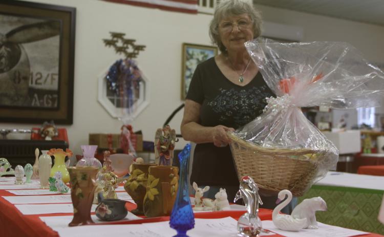 Vicki Shanks, who is helping organize the Gateway Art Gallery silent auction, shows off items that will be available during the fundraiser later in the month. (TONY BRITT/Lake City Reporter)