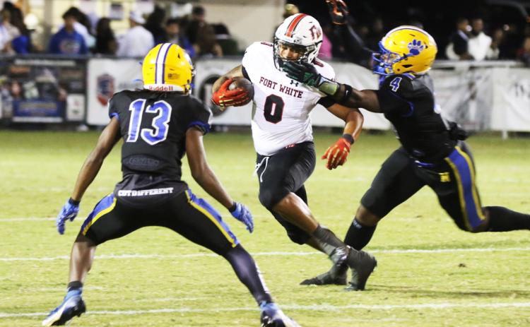 Fort White running back Lecosta Byrd gets his facemask grabbed by Newberry linebacker Logan Mccloud on Friday night. (MORGAN MCMULLEN/Lake City Reporter)