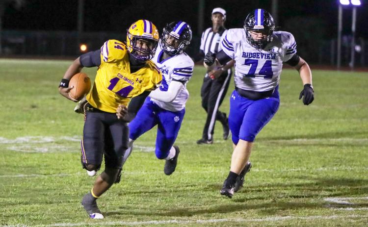 Columbia quarterback Xavier Collins scrambles up field away from the Ridgeview defense on Oct. 11. (BRENT KUYKENDALL/Lake City Reporter)