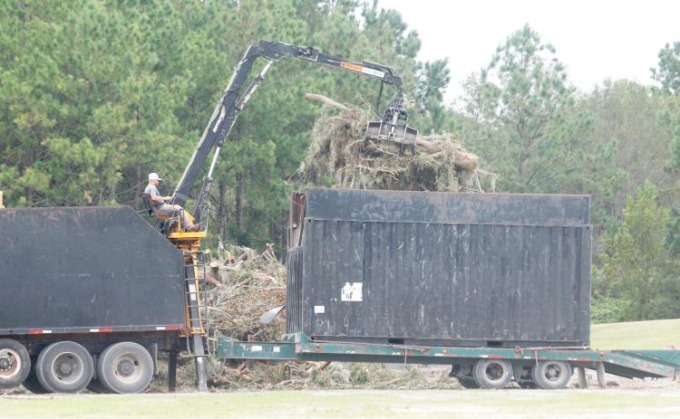 A contractor uses a mechanical lift to remove debris from the buckets of his truck on Tuesday afternoon at Columbia County Public Works. There are five double trucks that are going around the county collecting the organic debris that’s on county right-of-way. (TONY BRITT/Lake City Reporter)
