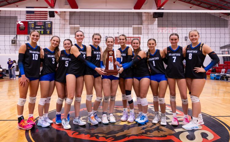 Branford's volleyball team poses with the District 6-R trophy after sweeping Union County on Thursday night. (JACK HOWDESHELL/Lake City Reporter)