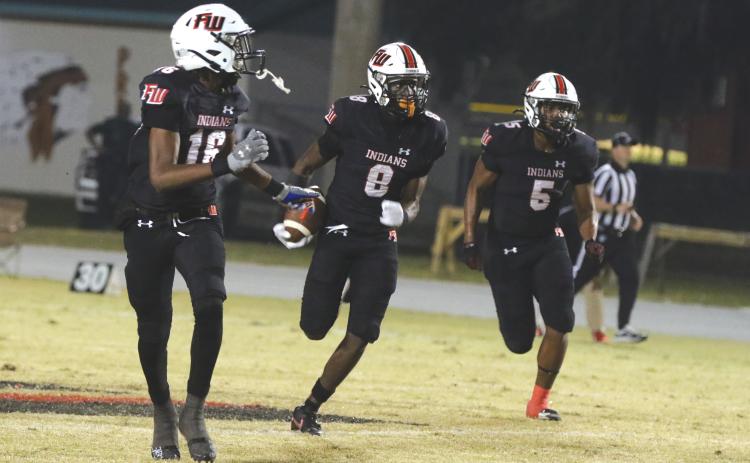 Fort White’s Jayden Jackson (8) looks for room to run on his first interception return for a touchdown Friday against Hilliard as DeSean Lally (16) and Darion Brinson (5) look to make a block. (MORGAN MCMULLEN/Lake City Reporter)