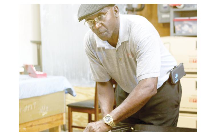 Robert Nelson, assembling a bed’s headboard, said the furniture has gotten heavier during the past five decades. (TONY BRITT/Lake City Reporter)