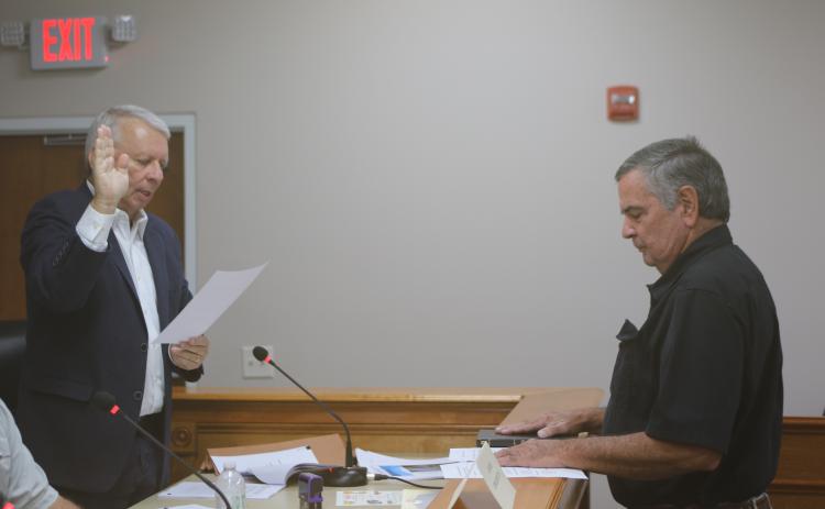 Grady Williams (from left), North Florida Water Utilities Authority Board of Directors legal counsel, swears in Steven Dicks as the board member at-large for the entity. (TONY BRITT/Lake City Reporter)