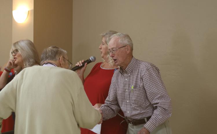 Donald Christensen (right) shakes hands with Kenneth Keen as the pair were among four veterans honored during Saturday’s annual veterans luncheon at the Florida Gateway Fairgrounds for being the oldest in attendance. Keen is 93 and Christensen is 94. Also recognized were Edward Fries, 93, and Wayne Morrell, 100. (TONY BRITT/Lake City Reporter)