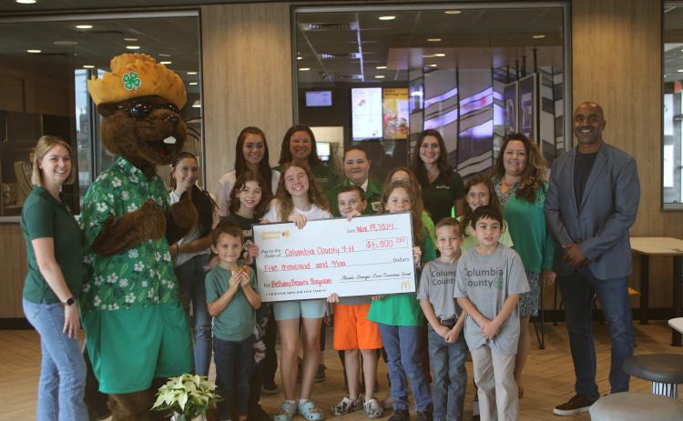 Columbia County Extension Service employees, Bellamy Beaver and youngsters in the local 4H program stand with McDonald’s officials during a check presentation on Tuesday afternoon. (TONY BRITT/Lake City Reporter)