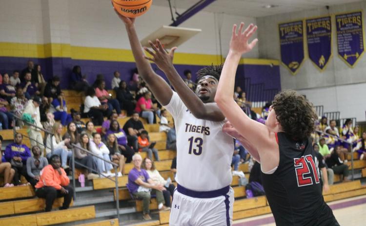 Columbia forward Zavian Douglas scores while defended by The Rock forward Hendrix Loughridge on Tuesday night. (JORDAN KROEGER/Lake City Reporter)